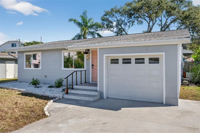 a view of a house with backyard and a tree