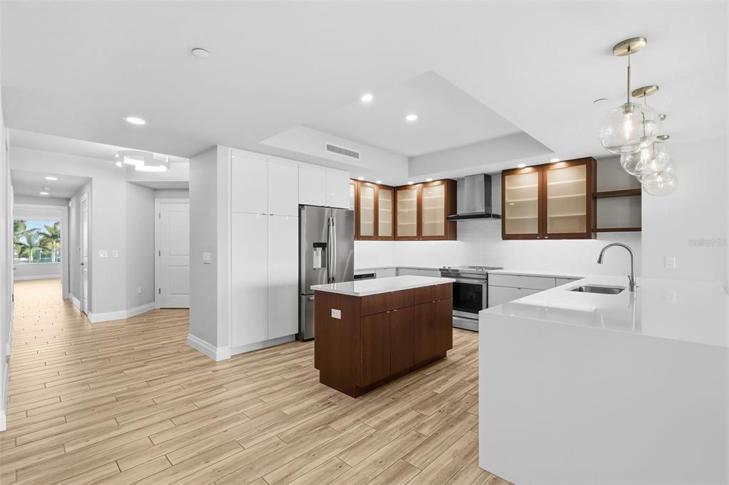 800 Collany Road, Unit 302 St. Petersburg, FL 33715 - Photo 16 of 66 a room with stainless steel appliances kitchen island granite countertop a refrigerator a sink dishwasher and a oven with wooden floor