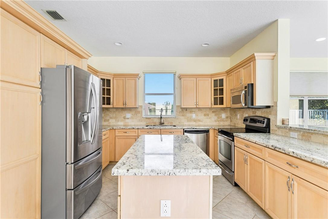 10945 Ravel Court Boca Raton, FL 33498 - Photo 11 of 24 a kitchen with stainless steel appliances granite countertop a refrigerator stove and oven