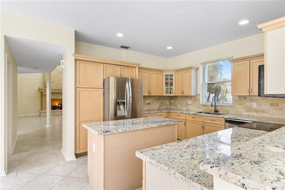 10945 Ravel Court Boca Raton, FL 33498 - Photo 13 of 24 a kitchen with stainless steel appliances granite countertop a sink stove and refrigerator
