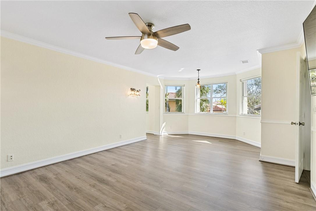 10945 Ravel Court Boca Raton, FL 33498 - Photo 17 of 24 an empty room with wooden floor fan and windows