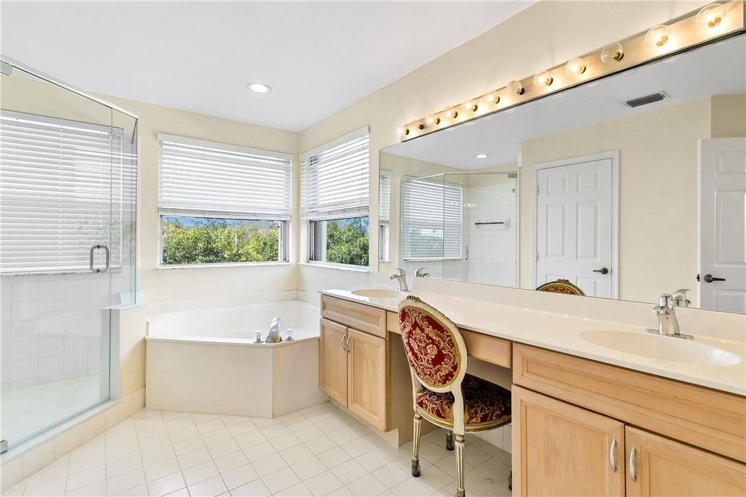 10945 Ravel Court Boca Raton, FL 33498 - Photo 18 of 24 a spacious bathroom with a granite countertop sink mirror and a bathtub