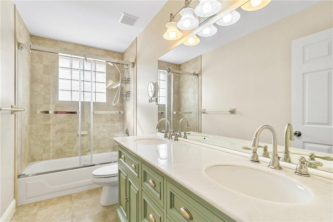 10945 Ravel Court Boca Raton, FL 33498 - Photo 19 of 24 a bathroom with a double vanity sink toilet and shower
