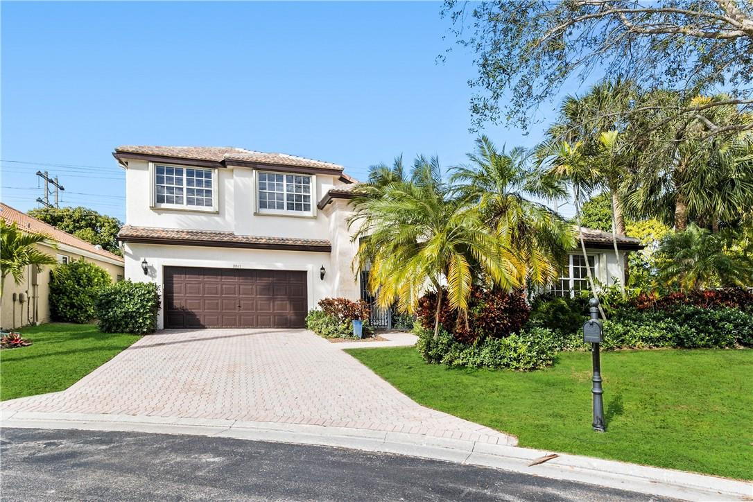 10945 Ravel Court Boca Raton, FL 33498 - Photo 2 of 24 a front view of a house with a garden
