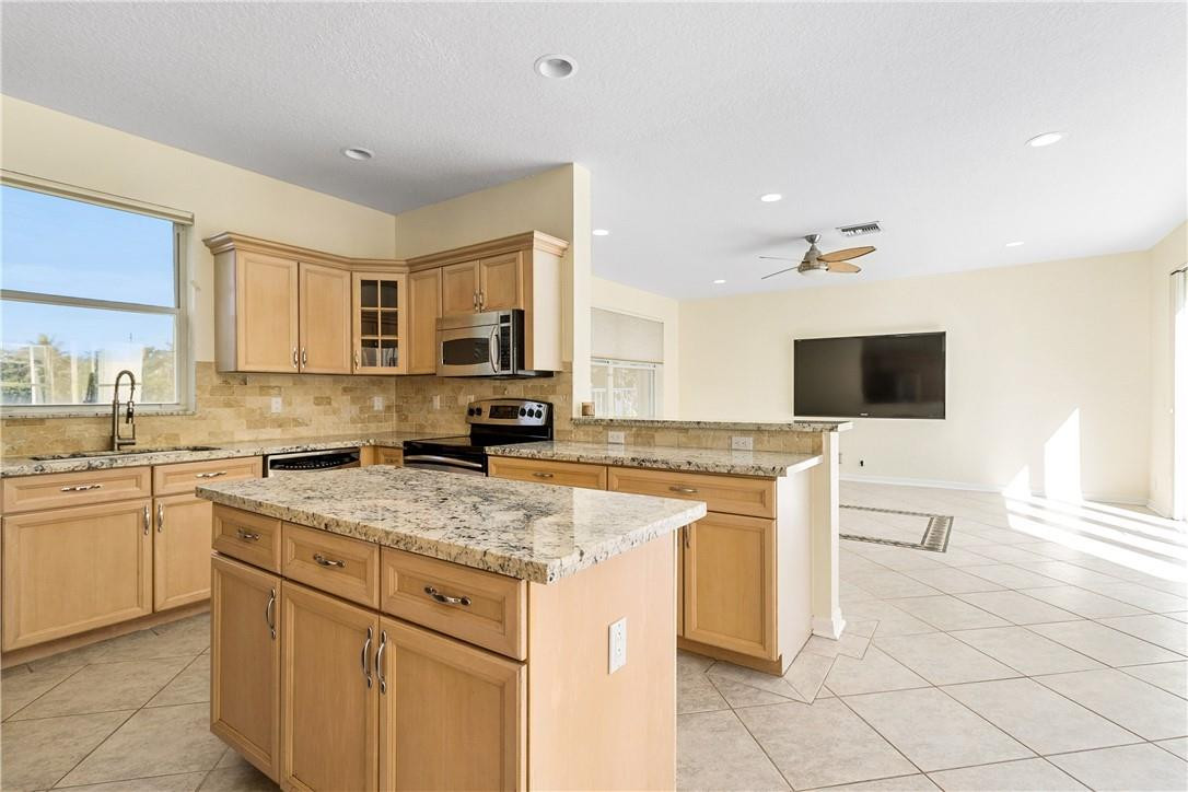 10945 Ravel Court Boca Raton, FL 33498 - Photo 10 of 24 a kitchen with cabinets appliances a sink and a counter top space
