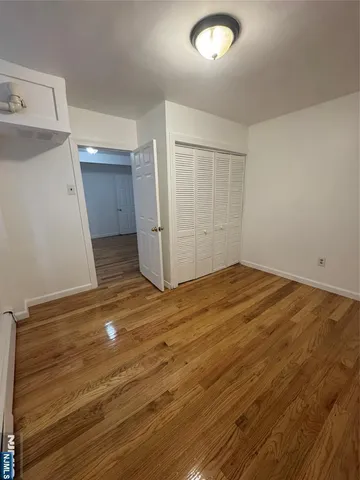 an empty room with wooden floor and entrance