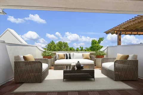 a balcony with furniture and a potted plant
