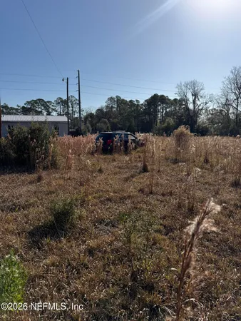 a view of a dry yard with wooden fence