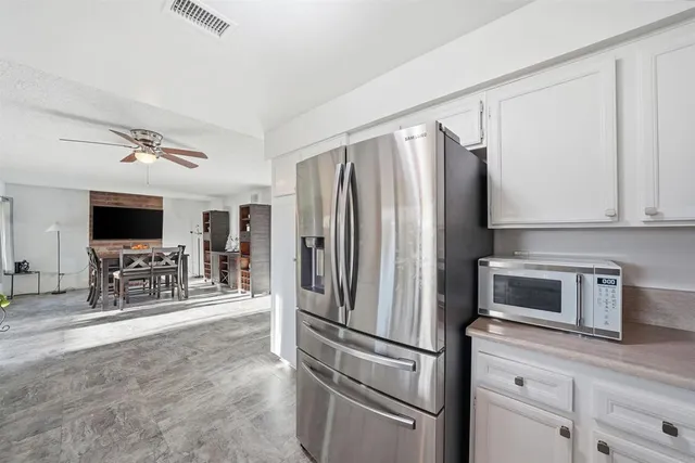 a kitchen with stainless steel appliances a refrigerator sink and microwave