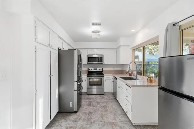 a kitchen with stainless steel appliances granite countertop a refrigerator stove and oven