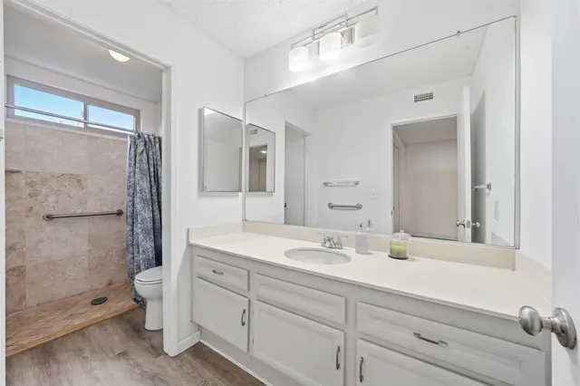 a bathroom with a double vanity sink toilet and shower