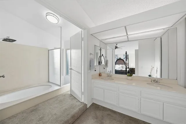 a spacious bathroom with a shower sink and mirror