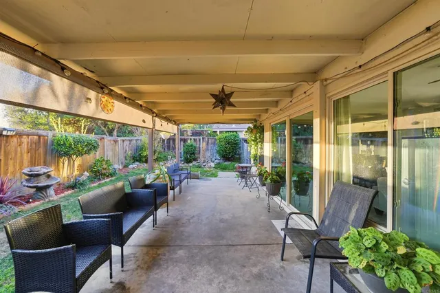 a view of a chair and table in backyard of the house
