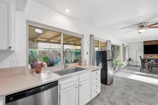 a kitchen with sink refrigerator and large window