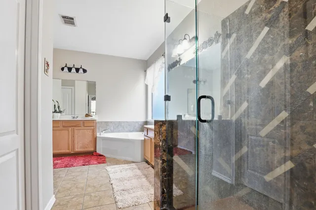 a spacious bathroom with a bathtub sink and mirror
