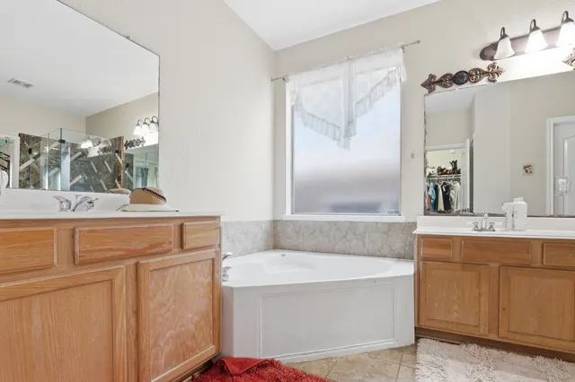 a bathroom with a tub sink and mirror