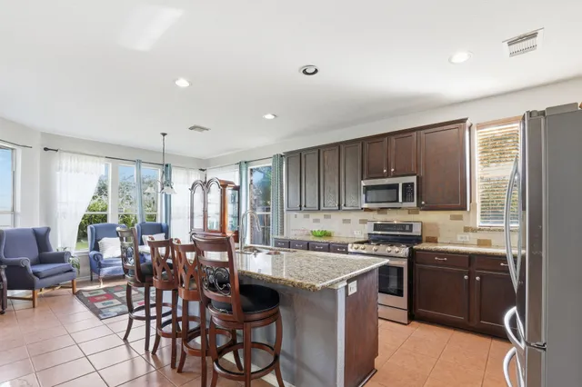 a kitchen with a table chairs sink and cabinets