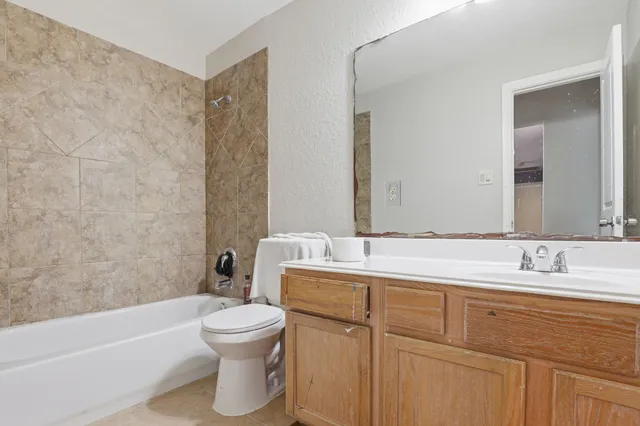 a bathroom with a double vanity sink toilet mirror and bathtub