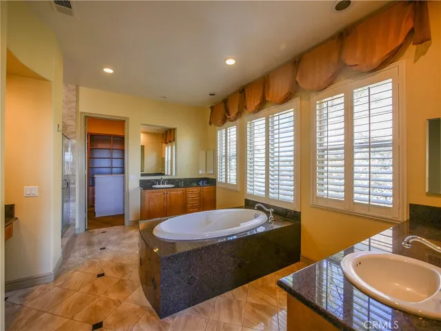 a bathroom with a sink a bathtub and a mirror