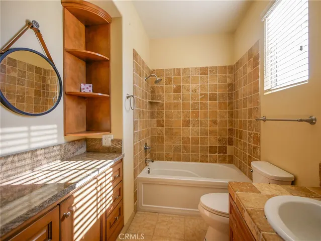 a bathroom with a granite countertop toilet sink and bathtub