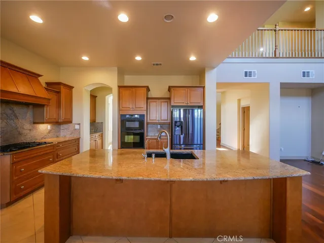 a kitchen with stainless steel appliances granite countertop a sink a stove and a refrigerator