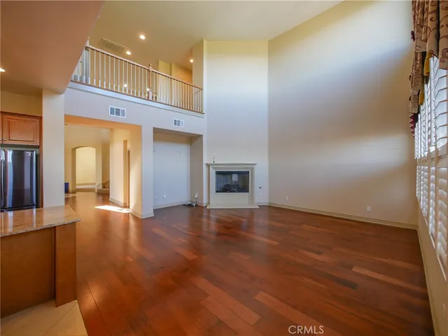 a view of empty room with wooden floor and fireplace