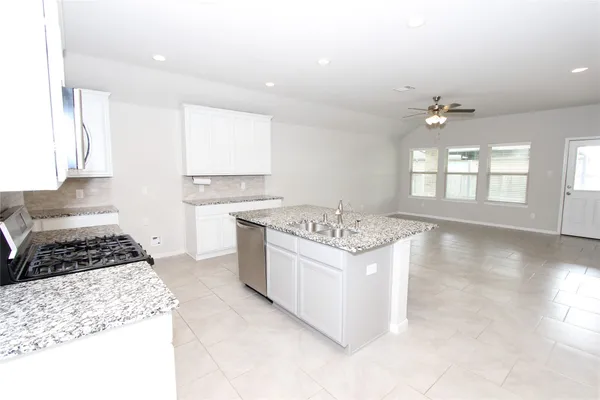 a kitchen with a stove a sink and a refrigerator