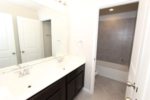 a bathroom with a tub sink and mirror