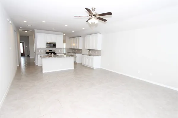 a view of a kitchen with kitchen island a sink stainless steel appliances and cabinets