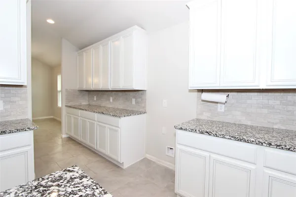 a kitchen with granite countertop a sink and a stove