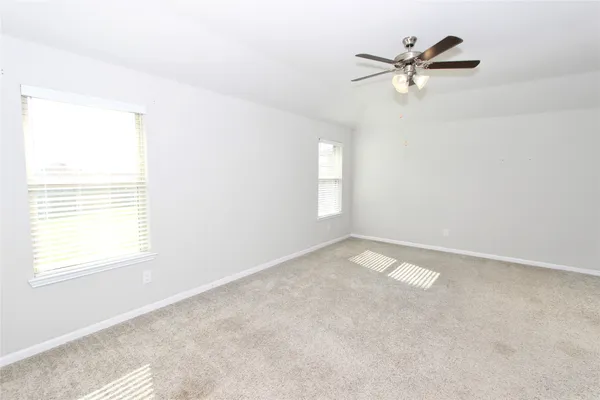 an empty room with a window and a fan