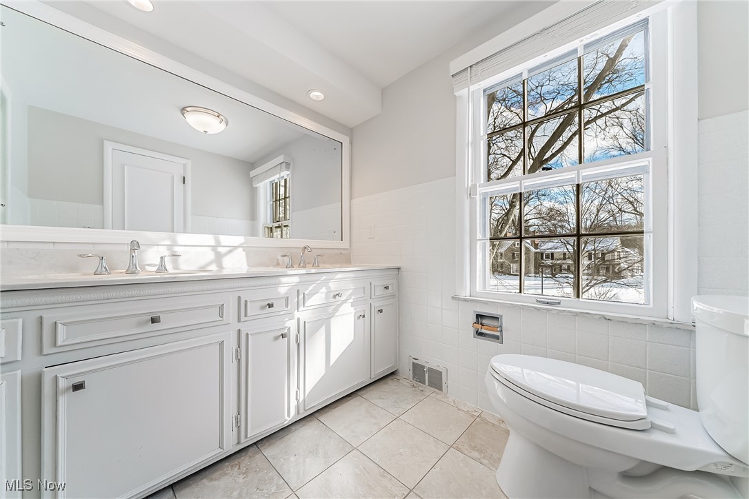 18201 Shelburne Road Cleveland, OH 44118 - Photo 18 of 36 Master bathroom featuring toilet, a wealth of natural light, tile walls, and vanity