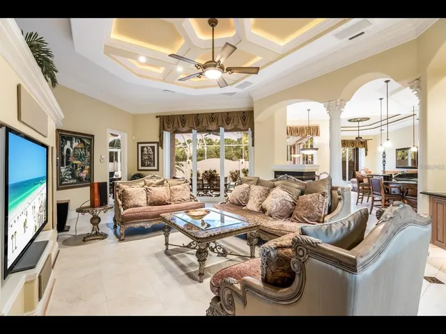 a living room with furniture a chandelier and a large window