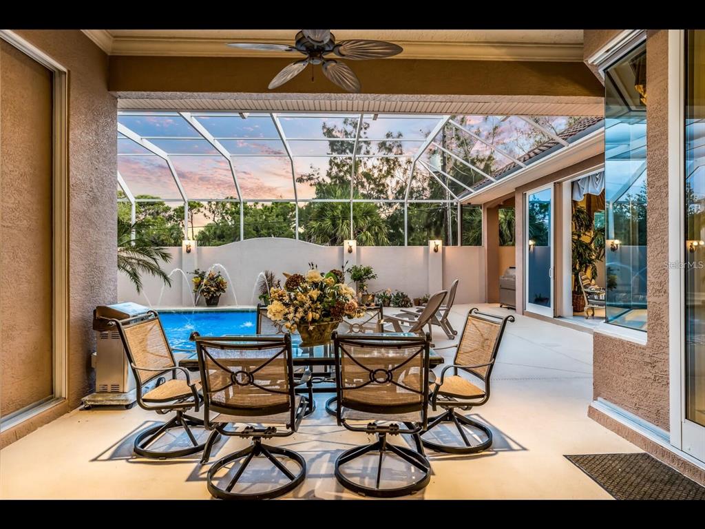 1102 Horizon View Drive Sarasota, FL 34242 - Photo 25 of 56 a view of a patio with table and chairs under an umbrella with a small yard