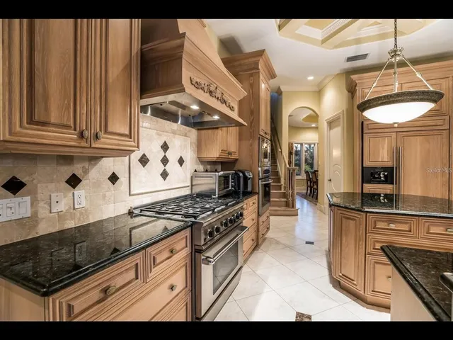 a kitchen with stainless steel appliances granite countertop a stove a sink and a microwave