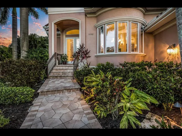 a front view of a house with a lots of potted plants