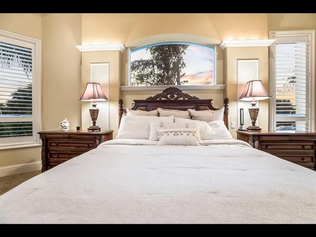 a bedroom with a bed and dresser with chair