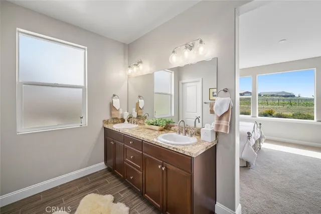 a bathroom with a granite countertop sink a toilet a mirror a vanity a bathtub and shower