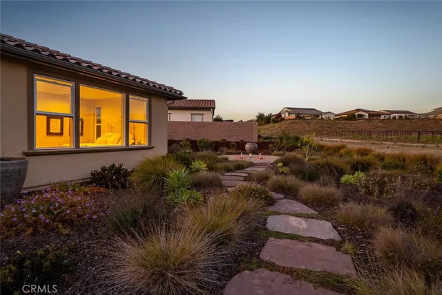 a front view of a house with a garden and plants