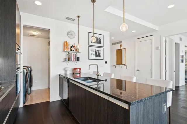 a kitchen with granite countertop a sink appliances and cabinets