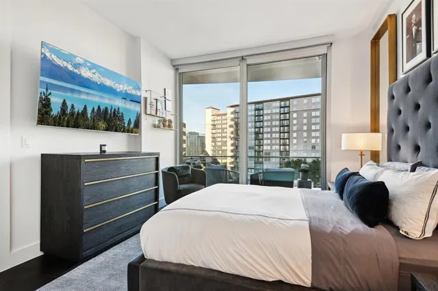 a bedroom with a large bed and a flat tv screen