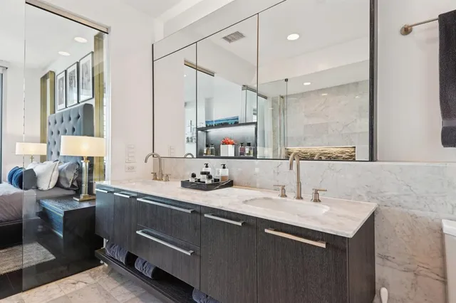 a bathroom with a double vanity sink a mirror and a shower