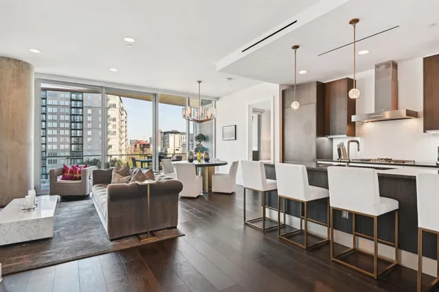 a living room with furniture wooden floor and a large window