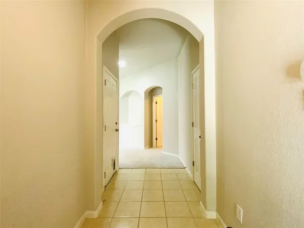 a view of a hallway with a glass door and a window
