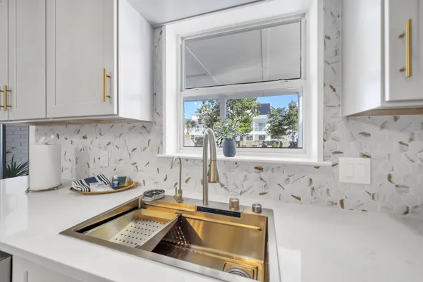 a bathroom with a granite countertop sink a mirror a shower and a toilet