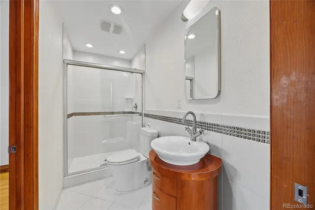 a bathroom with a granite countertop sink toilet and a mirror