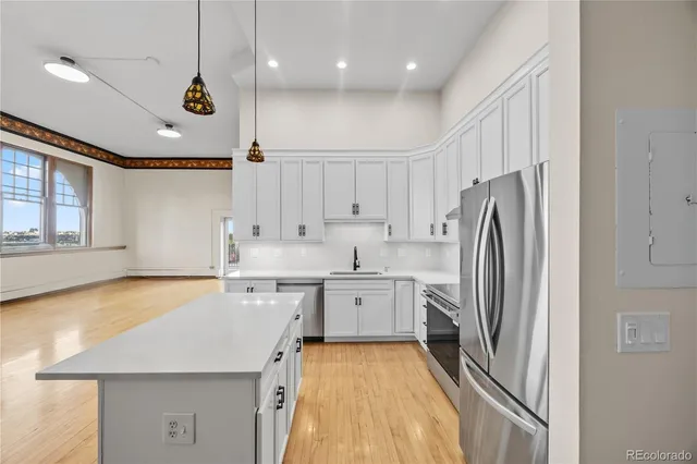 a large kitchen with a refrigerator a sink and dishwasher