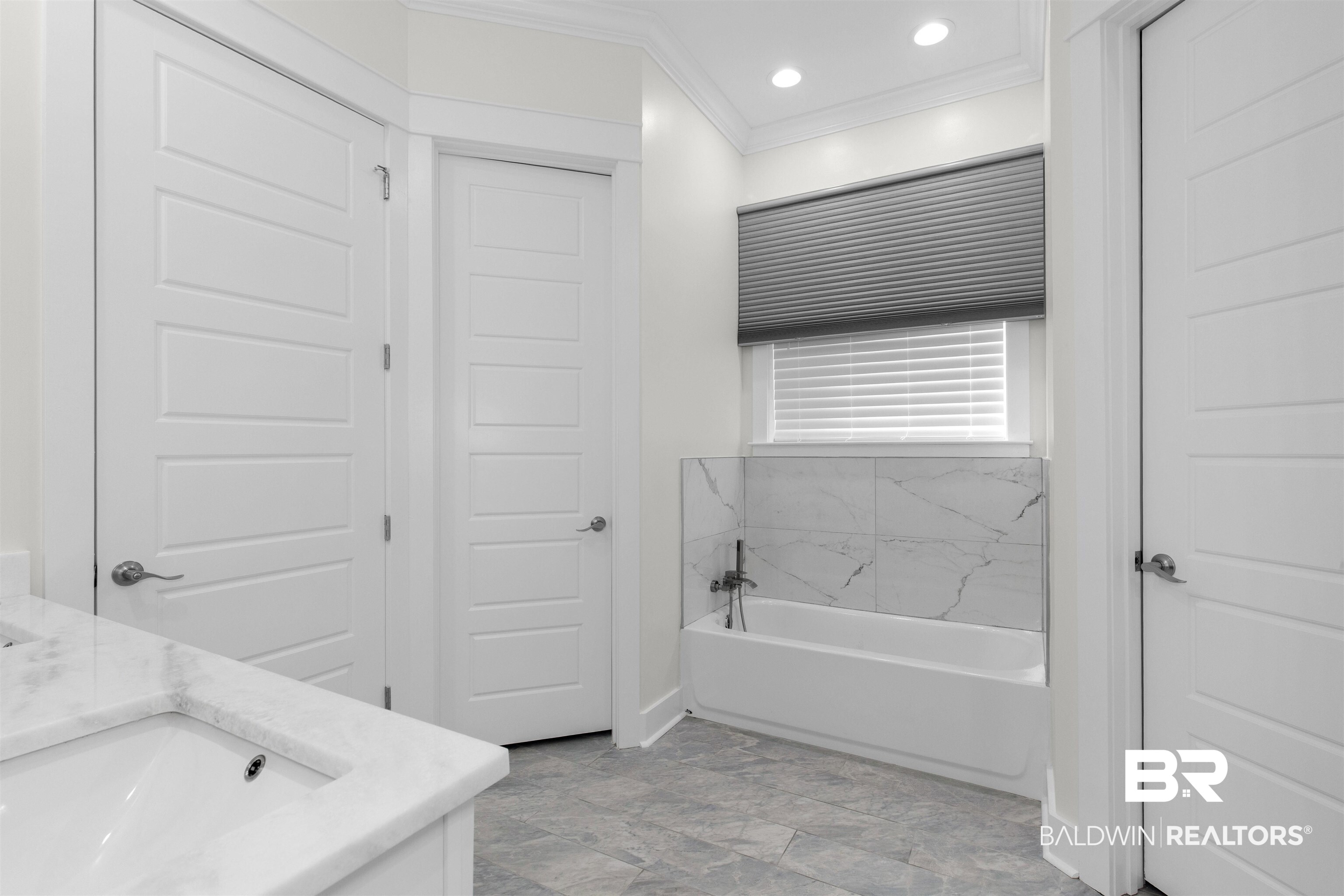 8069 Carmel Circle Foley, AL 36535 - Photo 17 of 23 Full bathroom with vanity, crown molding, recessed lighting, baseboards, and a tub to relax in