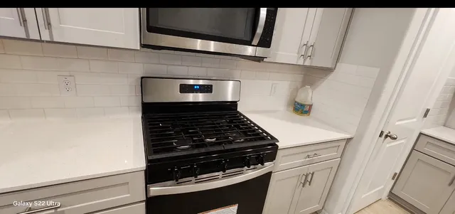 a sink sitting next to a white cabinet and next to a window