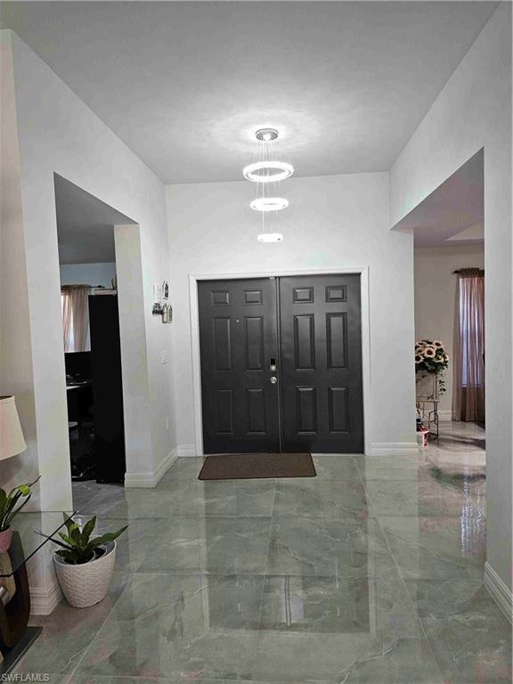 3507 2nd Street Southwest Lehigh Acres, FL 33976 - Photo 23 of 27 Foyer entrance featuring marble tiled floors and baseboards